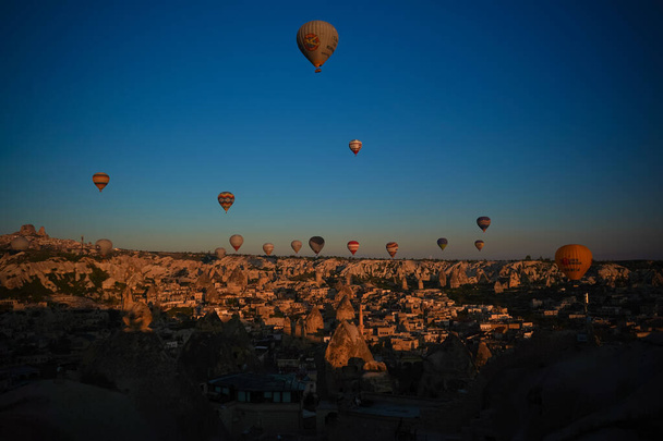 Auringonnousu panoraamanäkymät Goreme kaupunkiin ja lentävät ilmapallot, Cappadocia, Turkki
 - Valokuva, kuva