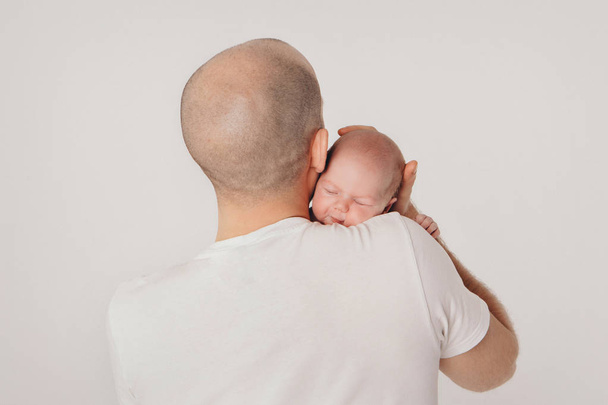 Dad holds the baby in his arms. The concept of educating the father of young children, Happy childhood, a friendly family. - 写真・画像