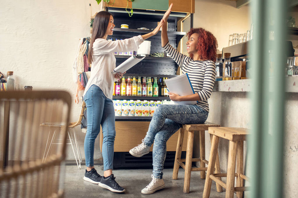 Curly friend giving high five to her business partner - Fotó, kép
