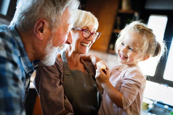 Happy smiling grandparents having fun times with children at home - Foto, imagen