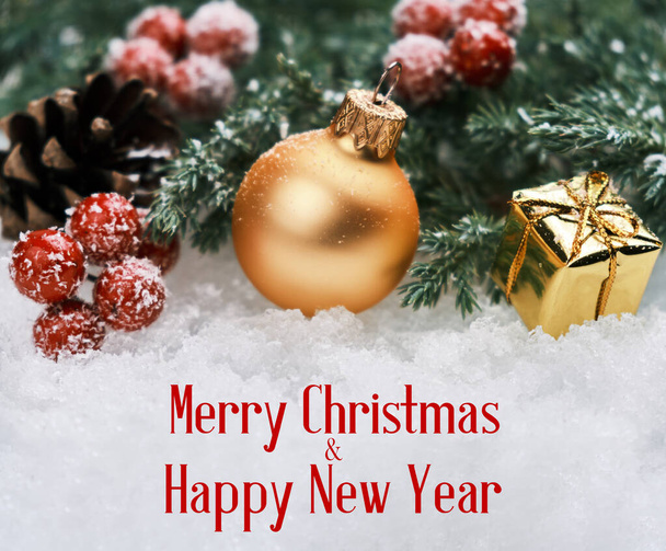 Fondo de Navidad con bola de Navidad dorada, caja de regalo, bayas rojas y rama de abeto en la nieve
 - Foto, Imagen