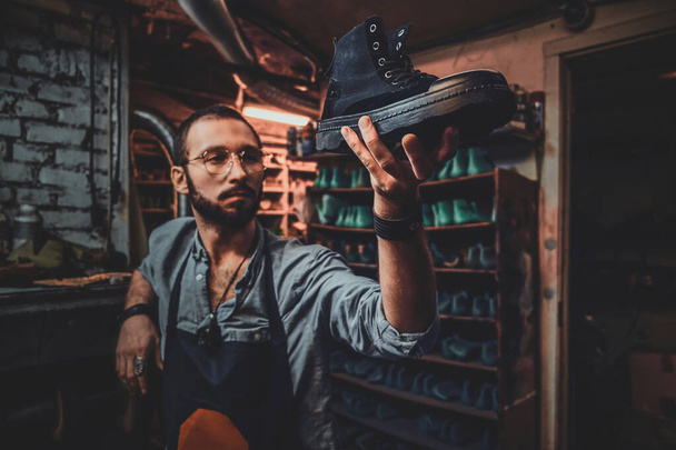 Shoemaker is kijken op gemaakt door hem schoen - Foto, afbeelding