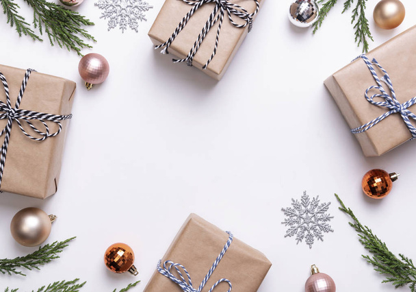 Kerstcompositie met decoraties en geschenkdoos met ster confetti op witte achtergrond. winter, nieuwjaarsconcept. Vlakke lay, bovenaanzicht, kopieerruimte. - Foto, afbeelding