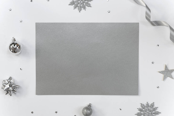 Mock up üdvözlő papír kártya fehér háttér karácsonyi dekorációk és konfetti. Meghívó kártya kialakítása szöveg. - Fotó, kép