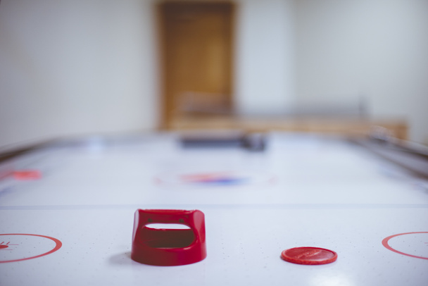 Primo piano di un tavolo da hockey aereo con il disco rosso e uno sfondo sfocato
 - Foto, immagini