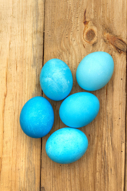 Concepto de Pascua con huevos de colores sobre fondo de madera, primer plano, vista superior
 - Foto, imagen