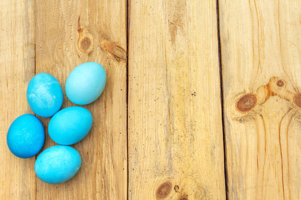 Concepto de Pascua con huevos de colores sobre fondo de madera, vista superior, espacio para copiar
 - Foto, Imagen