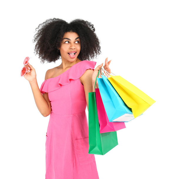Beautiful African-American woman with shopping bags on white background - Photo, image