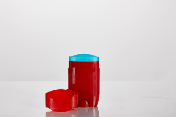 piros tekercs a fehér alapon izolált dezodor palackon - Fotó, kép