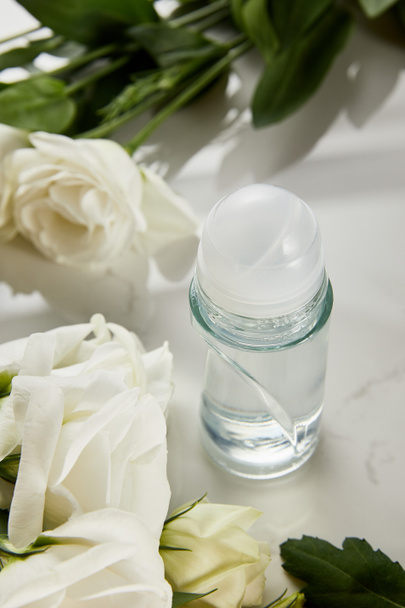 roll on bottle of deodorant with roses on white surface - Photo, Image