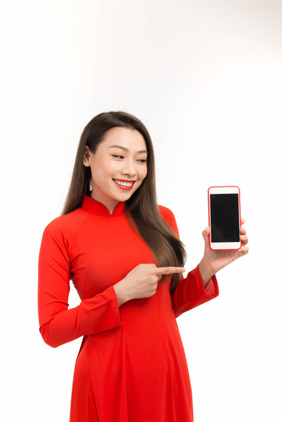 Портрет радісної азіатки, що показує порожній екран мобільного телефону ізольовано на білому тлі
 - Фото, зображення