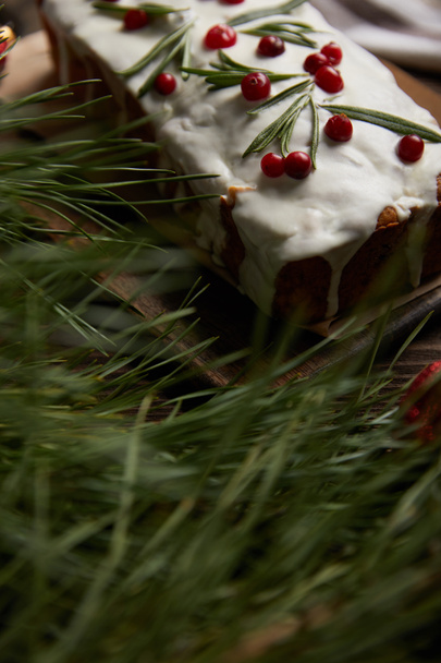 selective focus of traditional Christmas cake with cranberry near pine branch - Fotografie, Obrázek