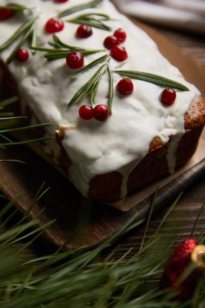 selective focus of traditional Christmas cake with cranberry near pine branch - Valokuva, kuva