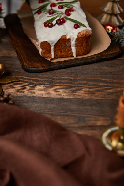 茶色のナプキンで木製のテーブルの上にクランベリーと伝統的なクリスマスケーキ - 写真・画像