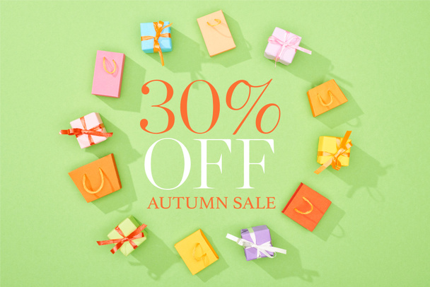 round frame of decorative gift boxes and shopping bags on green background with 30 percent off autumn sale illustration  - Photo, Image