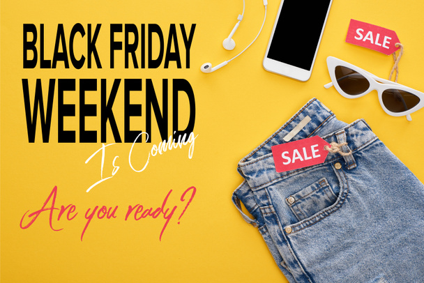 vista dall'alto di jeans, occhiali e smartphone con auricolari con etichette di vendita su sfondo giallo con illustrazione del venerdì nero
 - Foto, immagini