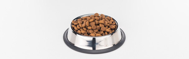 dry pet food in silver bowl isolated on white, panoramic shot - 写真・画像