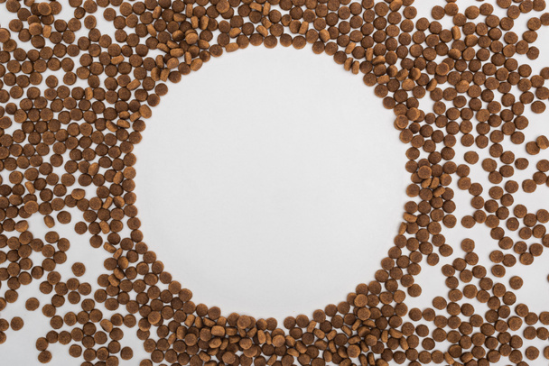 round frame of dry pet food scattered isolated on white - Zdjęcie, obraz