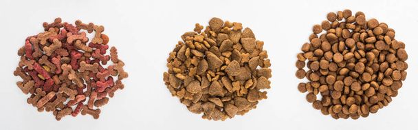top view of assorted dry pet food in piles isolated on white, panoramic shot - 写真・画像