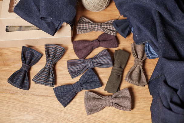 Bow ties made of wool on oak wooden table, adds a finished product. Small craft production - Photo, Image