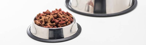 nourriture sèche fraîche pour animaux de compagnie dans des bols en argent isolés sur blanc, panoramique
 - Photo, image