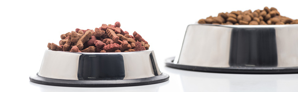 selective focus of assorted dry pet food in bowls isolated on white, panoramic shot - Fotó, kép