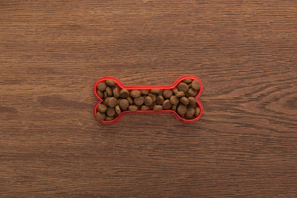 top view of dry pet food in bone on wooden table - Photo, Image