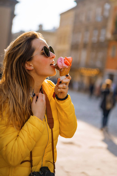 nuori nainen turisti, syö jäätelöä, onnellinen, nauraa, valoisa aurinkoinen päivä, turisti kamera. - Valokuva, kuva