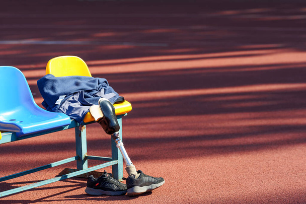 Prosthetic leg, sneakers and jacket on a seat at the stadium. - Fotografie, Obrázek
