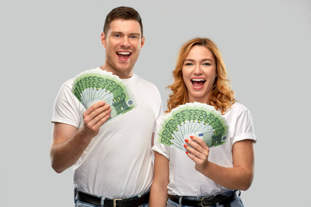 szczęśliwa para w białych koszulkach z pieniędzmi euro - Zdjęcie, obraz