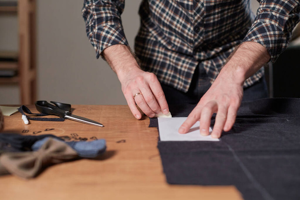 Tailor cutting wool fabric. the line pattern. Craftsman Makes rectangular blanks for Bow ties of woolen fabric. Work with sewing machine in a textile studio. - Фото, зображення