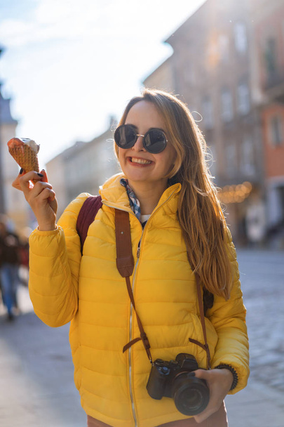 young woman tourist, eating ice cream, happy, laughing, bright sunny day, tourist camera. - Zdjęcie, obraz