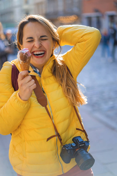 young woman tourist, eating ice cream, happy, laughing, bright sunny day, tourist camera. - Foto, Imagem