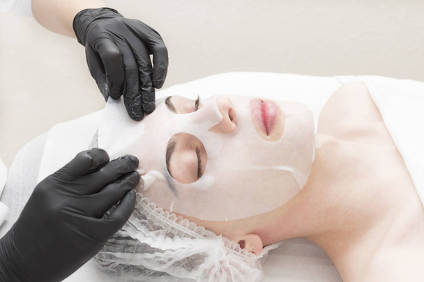 Η διαδικασία είναι ένα καθαριστικό υγρό μάσκα αποκατάστασης για τους άνδρες σε ένα σαλόνι ομορφιάς. - Φωτογραφία, εικόνα