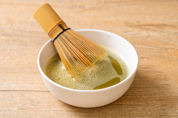 hot matcha green tea cup with green tea powder and whisk - Photo, image