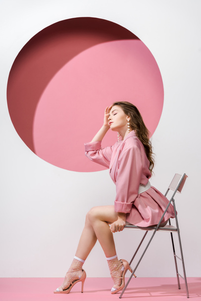 beautiful girl sitting on chair on white and pink  - Foto, Bild