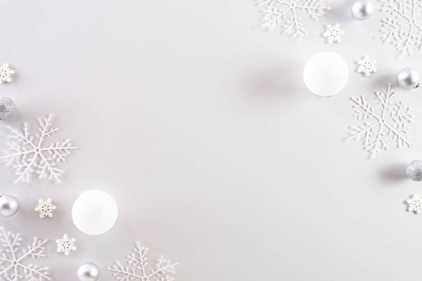 Christmas background concept. Top view of Christmas ball with snowflakes on light gray pastel background. - Photo, image