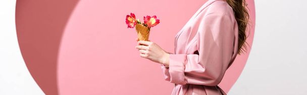 plano panorámico de mujer sosteniendo cono de helado con flores en blanco y rosa
  - Foto, Imagen