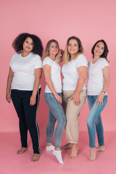 Two plus-size models and two skinny girls in white t-shirts. Design on white womens t-shirts - Fotoğraf, Görsel