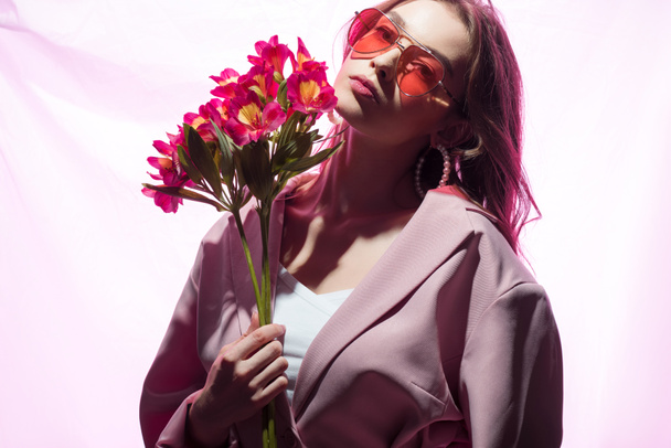 beautiful woman in sunglasses holding flowers on white - Fotó, kép