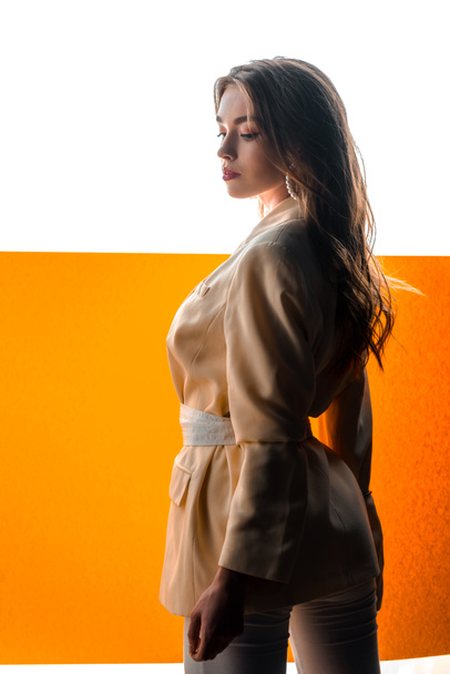 young beautiful woman in blazer with belt on orange and white  - Photo, image