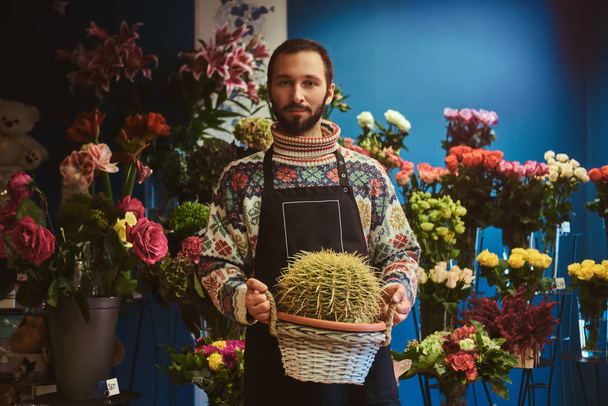 Portrait of young florist with cactus - Foto, imagen