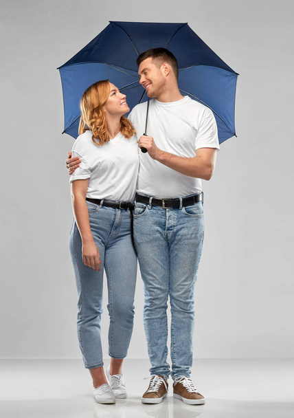 happy couple in white t-shirts with umbrella - Zdjęcie, obraz