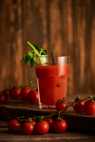selective focus of bloody mary cocktail in glass on wooden background with tomatoes - Photo, Image