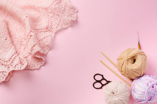 Wooden knitting needles, scissors and bright yarn. Accessories for Knitting. Lies on a pink-beige background. Top view. - Photo, image