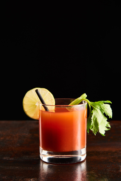 blutiger Cocktail im Glas garniert mit Limette und Sellerie isoliert auf schwarz - Foto, Bild