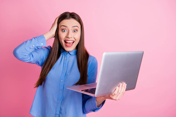 Photo of stylish trendy cute beautiful charming blogger having just won lottery and received notification into email wearing blue shirt isolated over pink color pastel background - Photo, Image