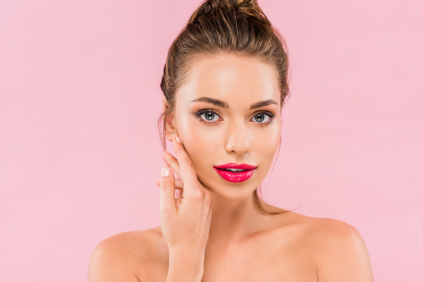 naked beautiful woman with pink lips posing with hand near face isolated on pink  - Foto, Imagen