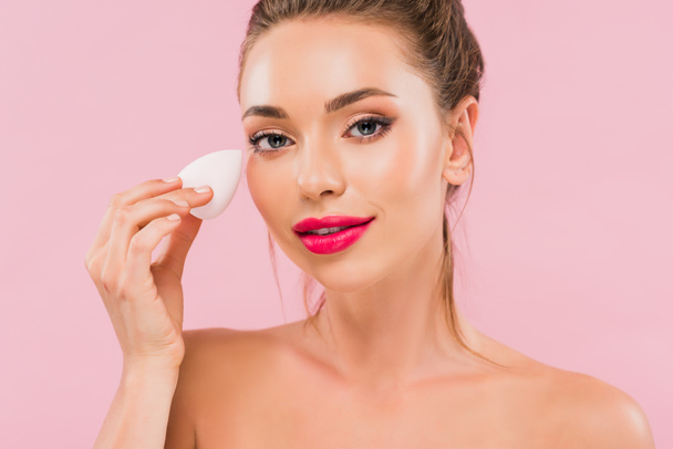 naked beautiful woman with pink lips holding makeup sponge isolated on pink  - Fotografie, Obrázek