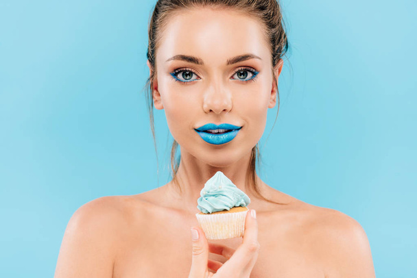 hermosa mujer desnuda con labios azules y magdalena aislado en azul
 - Foto, Imagen